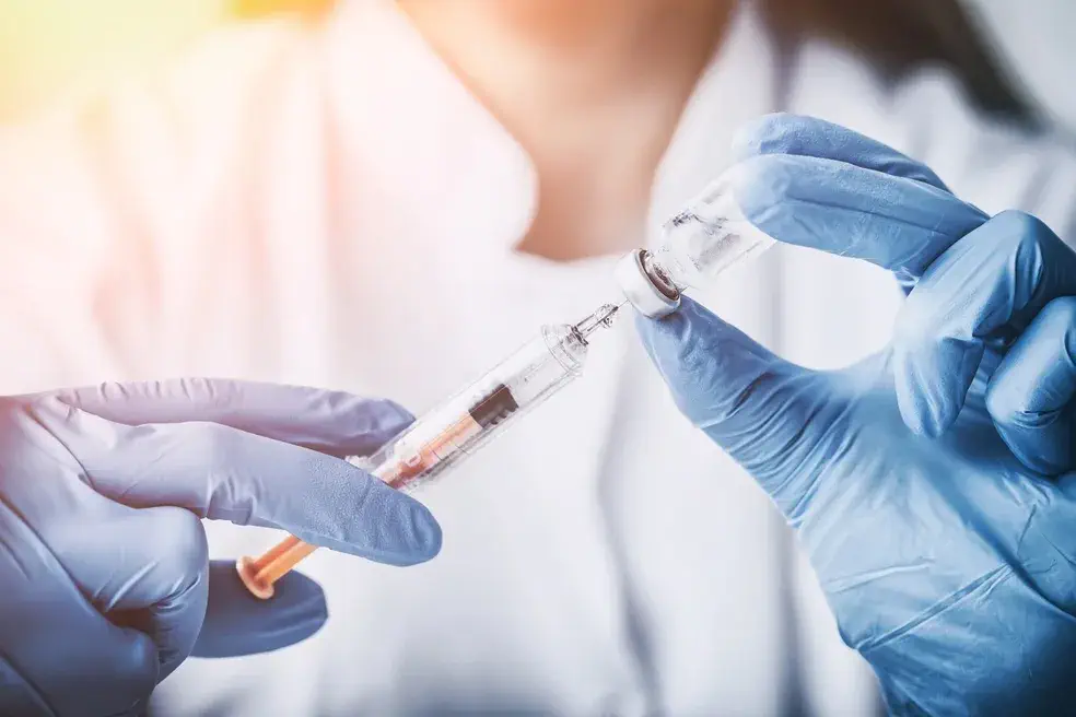 Healthcare practitioner preparing a vitamin injection